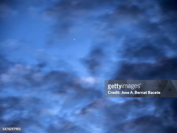 full frame of the sky at sunset with the planets venus and mercury on the horizon with moving clouds. - venus atmosphere stock pictures, royalty-free photos & images