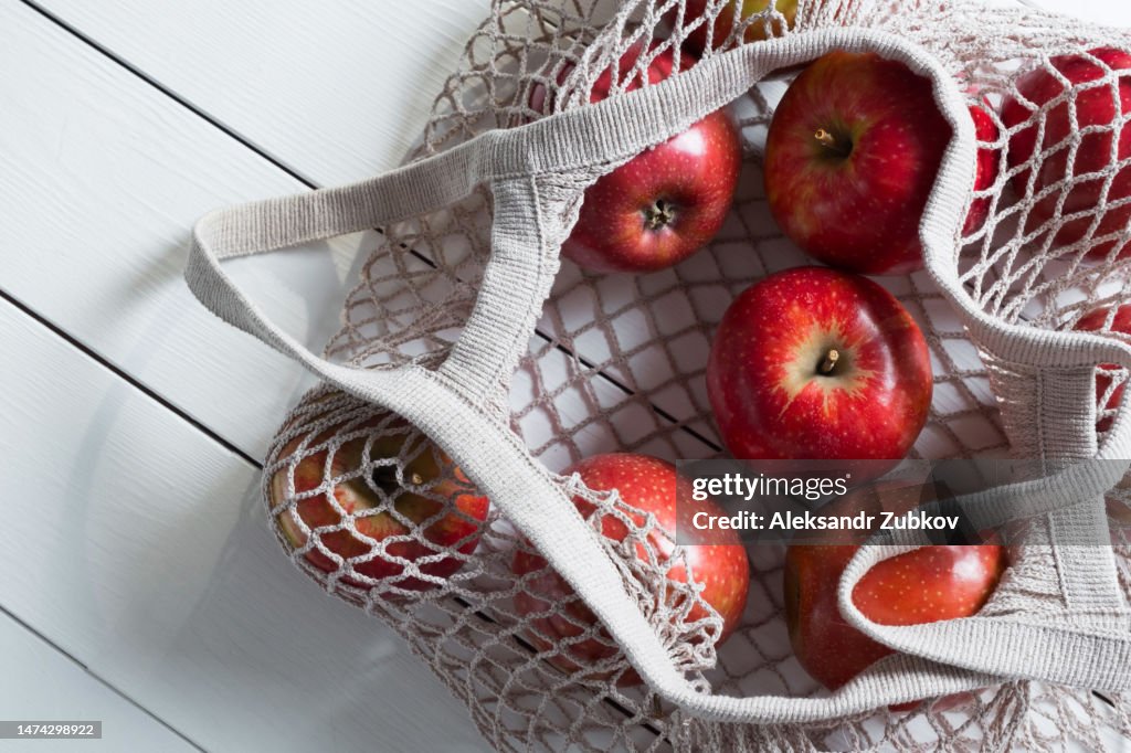 Fresh Juicy Organic Farm Fruits Products In A Reusable Shopping Bag Apples  In A String Bag Made Of Recycled Materials On A White Wooden Table Or  Background Vegetarianism Veganism Raw Food Alternative