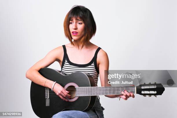 young woman playing the guitar, and singing - practice stock pictures, royalty-free photos & images