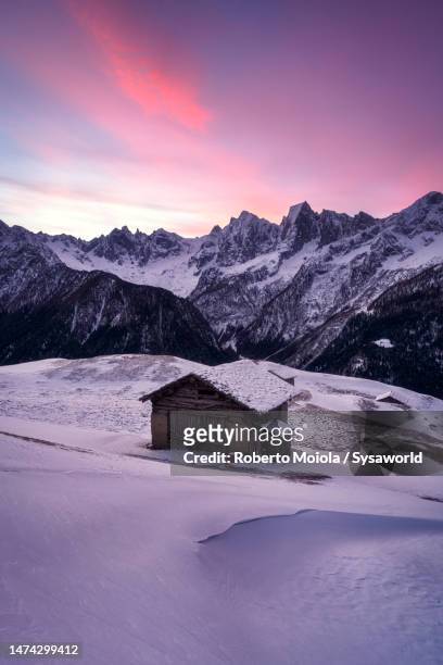 snowy mountain hut at dawn, tombal, switzerland - alpen berghütte stock-fotos und bilder