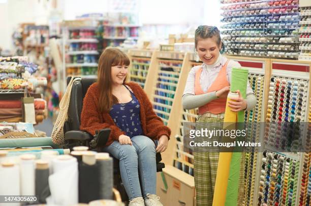 colleagues in a textile studio space - wheelchair accessibility stock pictures, royalty-free photos & images
