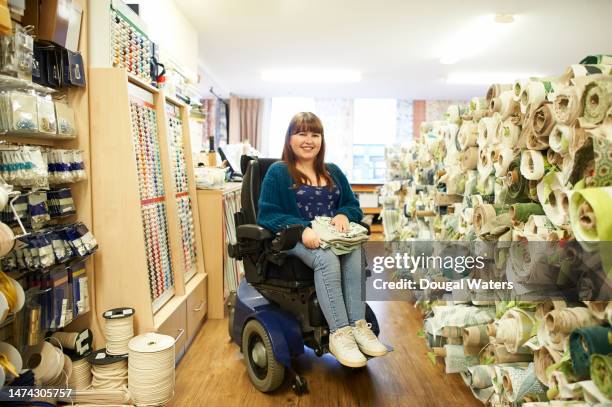 portrait of a woman in a textile, home interiors store - behindertenwerkstatt stock-fotos und bilder