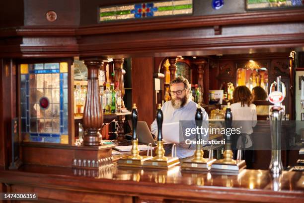 pub landlord preparing his paperwork - bar stock pictures, royalty-free photos & images