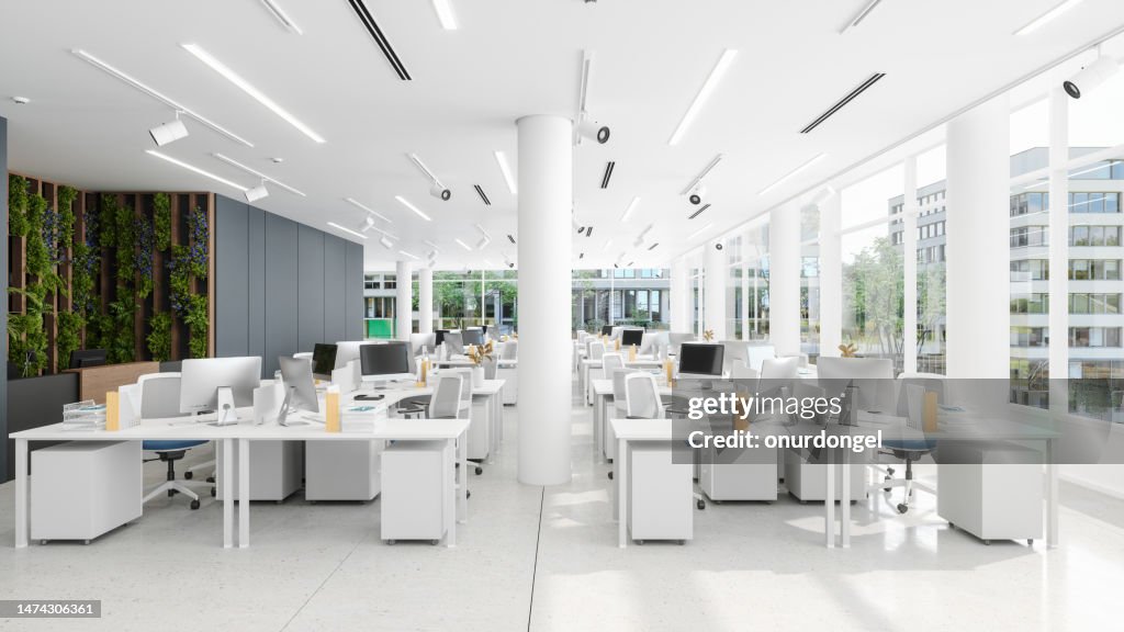 Eco-Friendly Coworking Office Space With Tables, Office Chairs, Computers And Vertical Garden