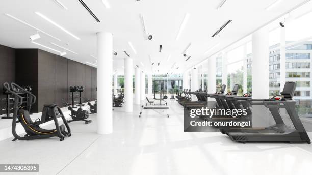 interior moderno del gimnasio con cintas de correr, bicicletas estáticas, equipos deportivos y vista a la ciudad a través de la ventana - gimnasio fotografías e imágenes de stock