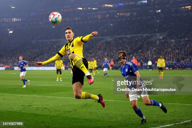 Nico Schlotterbeck of Borussia Dortmund attempts to control the ball before it goes out of play, whilst under pressure from Cedric Brunner of FC...