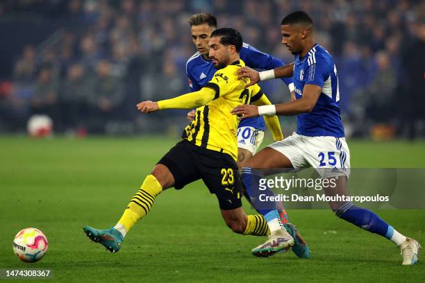 Emre Can of Borussia Dortmund battles for the ball with Moritz Jenz and Rodrigo Zalazar Martinez of Schalke during the Bundesliga match between FC...