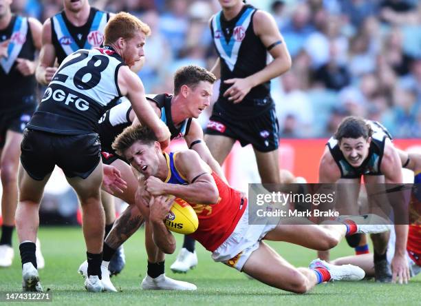 Zac Bailey of the Lions gets caught high by Kane Farrell and Willem Drew of Port Adelaide during the round one AFL match between Port Adelaide Power...