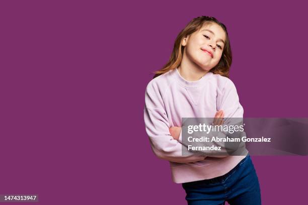 cool little girl looking at the camera - kids standing crossed arms stock-fotos und bilder