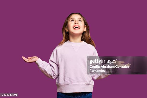 cute little girl looking up with happy expression - child shock studio stock-fotos und bilder