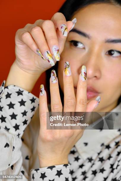 close up detail of an asian woman showing her beautiful nails - images of nail art designs stock pictures, royalty-free photos & images