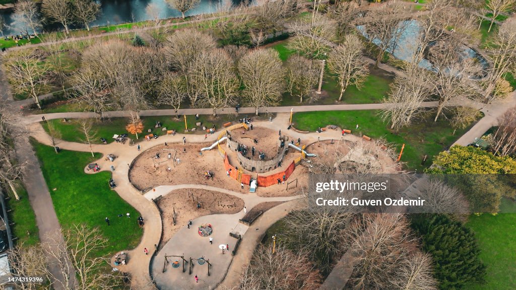 Aerial children's amusement park, swings and slides, happy children, children playing in the park and their families, big park in the city,playground in cloudly day, Kindergarten, primary school playground background