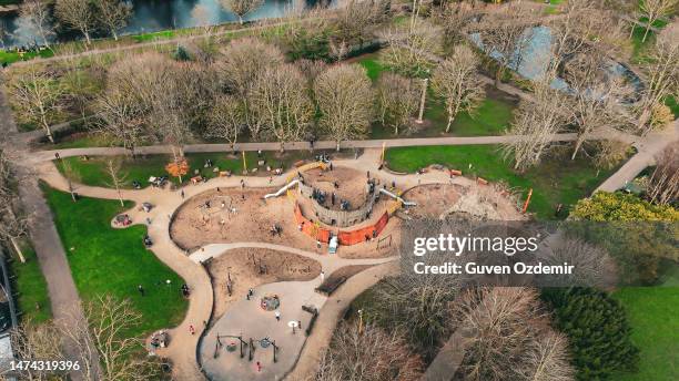 aerial children's amusement park, swings and slides, happy children, children playing in the park and their families, big park in the city,playground in cloudly day, kindergarten, primary school playground background - aerial view of childs playground stock pictures, royalty-free photos & images