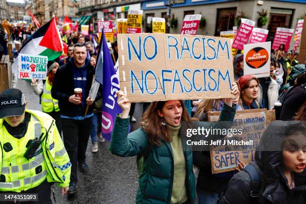 People carry placards as they march during a Stand Up To Racism protest at George Square on March 18, 2023 in Glasgow, Scotland. Given the rise of...