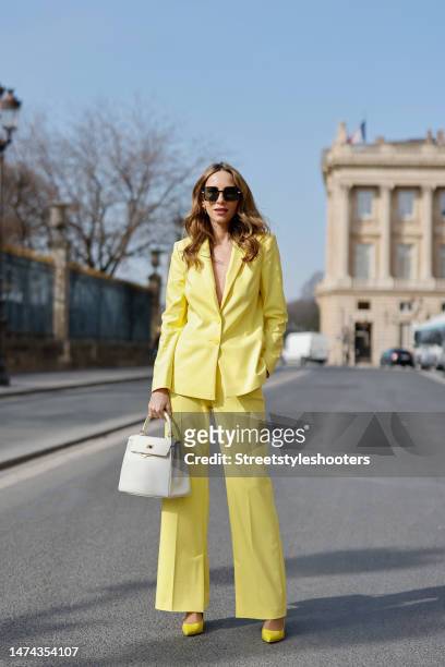 Alexandra Lapp is seen wearing COMMA blazer and trousers in yellow, Chanel flap bag in white, CHRISTIAN LOUBOUTIN Hot Chick pumps in yellow, and FOR...