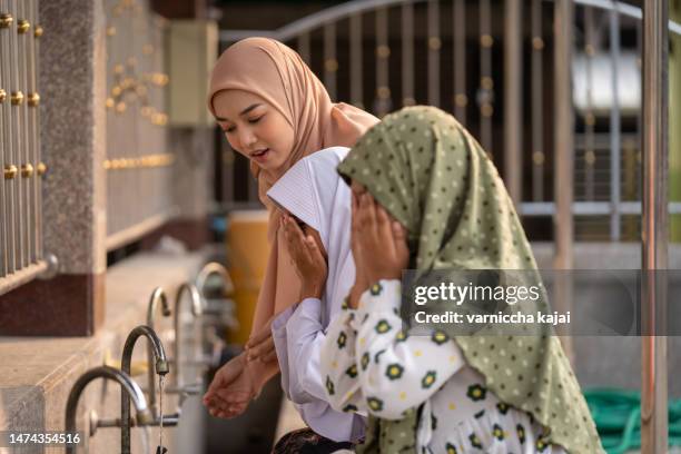 beautiful muslim girls in hijab and children clean their bodies before praying. - muslim prayer stock pictures, royalty-free photos & images