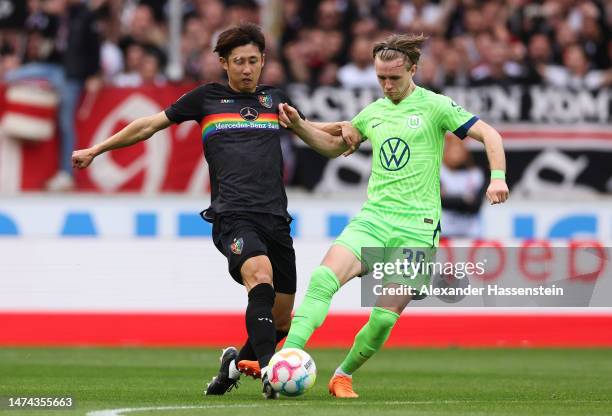 Hiroki Ito of VfB Stuttgart is challenged by Patrick Wimmer of VfL Wolfsburg during the Bundesliga match between VfB Stuttgart and VfL Wolfsburg at...