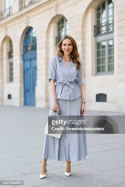 Alexandra Lapp is seen wearing MADELEINE linen blouse and skirt in light blue, and CHRISTIAN LOUBOUTIN Hot Chick pumps in white and vintage CHANEL...