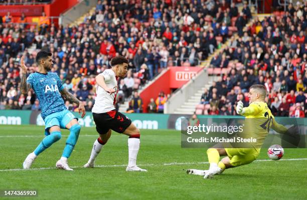 Che Adams of Southampton scores the team's first goal past Fraser Forster of Tottenham Hotspur while under pressure from Cristian Romero of Tottenham...