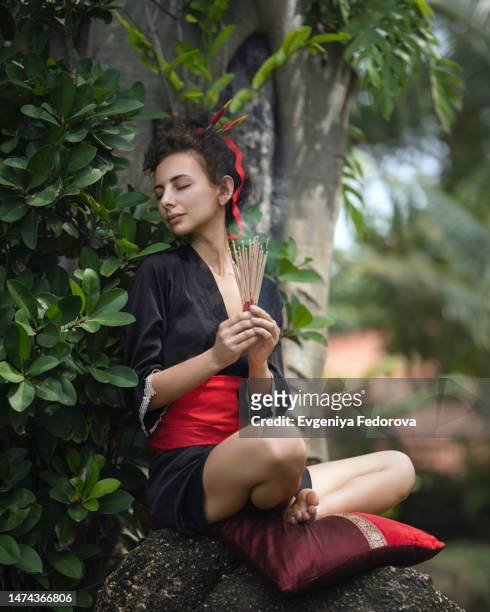 girl in a black kimono in a tropical forest on a large stone - open day 12 stock pictures, royalty-free photos & images