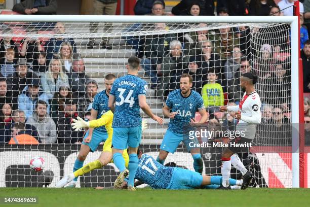 Theo Walcott of Southampton scores the team's second goal while under pressure from Cristian Romero of Tottenham Hotspur during the Premier League...