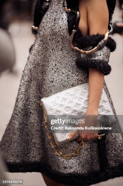 Guest is seen wearing gold Louis Vuitton earrings, a silver and black wool with wavy large borders and cut-out shoulders Louis Vuitton dress, a grey...