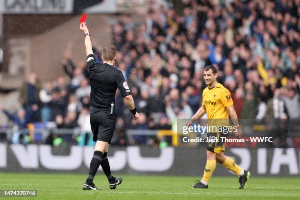 Jonny of Wolverhampton Wanderers is shown a red card from Referee Michael Salisbury during the Premier League match between Wolverhampton Wanderers...