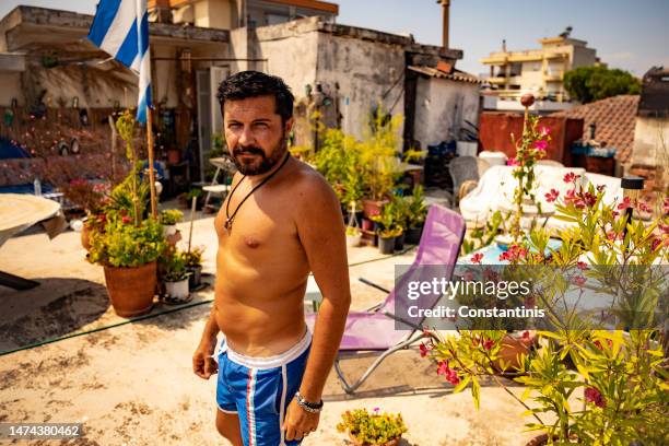 man of greek ethnicity enjoying summer day on his garden rooftop - greek ethnicity stock pictures, royalty-free photos & images