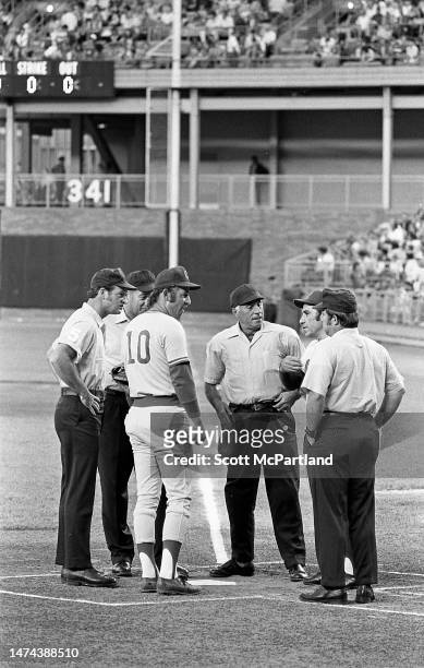 American baseball player Ron Santo , of the Chicago Cubs, and New York Mets team manager Yogi Berra talk with unidentified umpires at home plate...