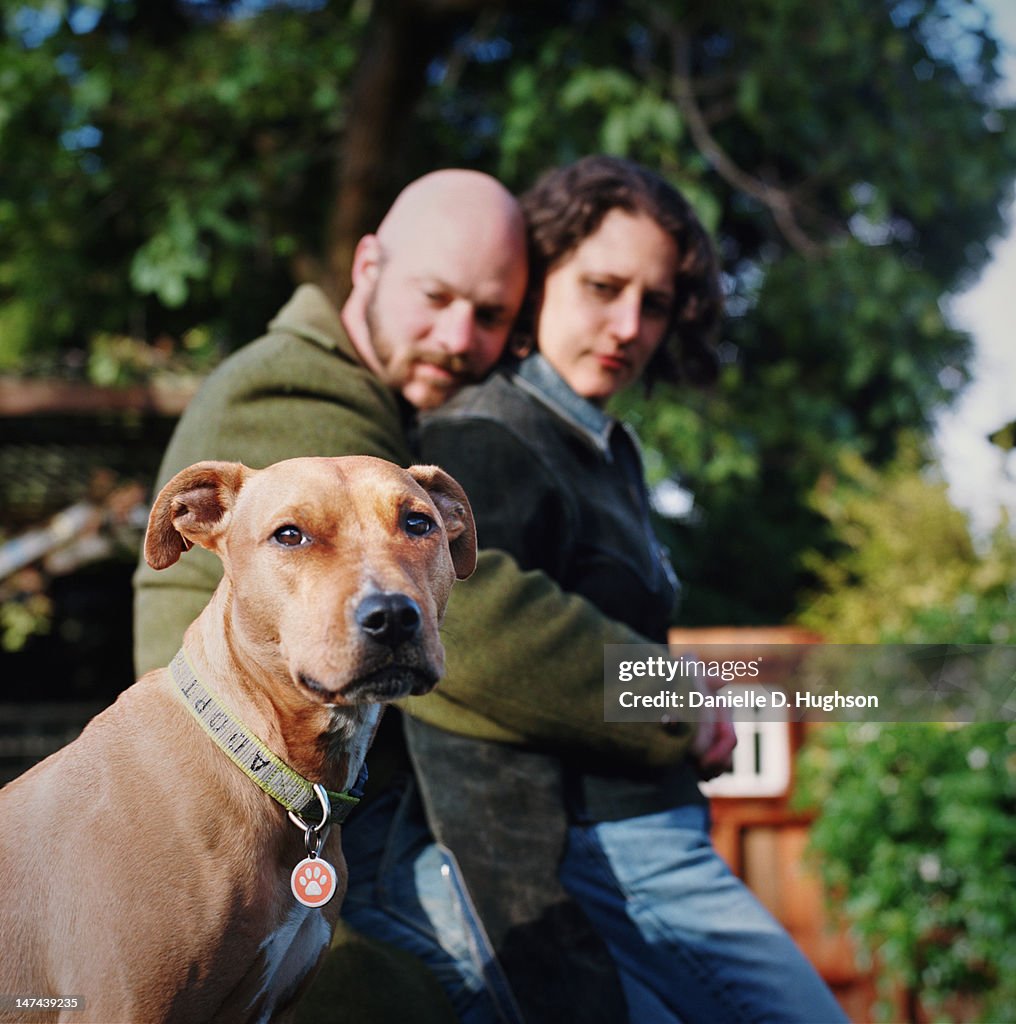Dog in front of hugging couple