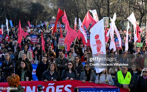 Demonstrators hoist signs and flags while listening to CGT-IN Secretary-General Isabel Camarinha in Praça Resturadores at the end of a rally through...