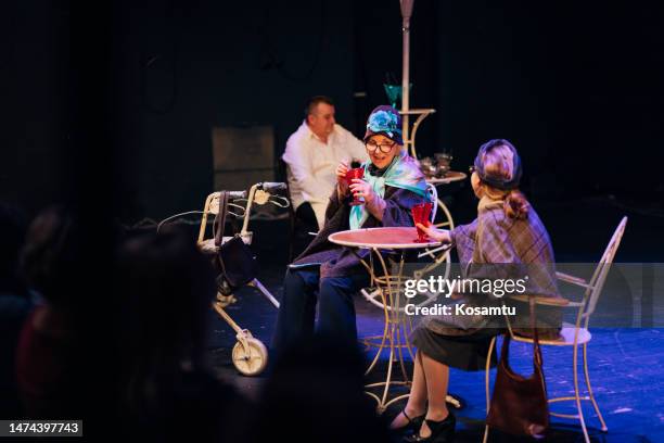 three professional actors in costumes perform a play in front of the audience, the scene looks like a pastry shop - backstage audience stock pictures, royalty-free photos & images