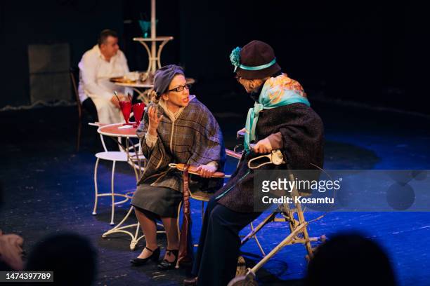smaller group of professional actors in costumes perform a play in front of the audience, the scene looks like a pastry shop - actor chair stock pictures, royalty-free photos & images