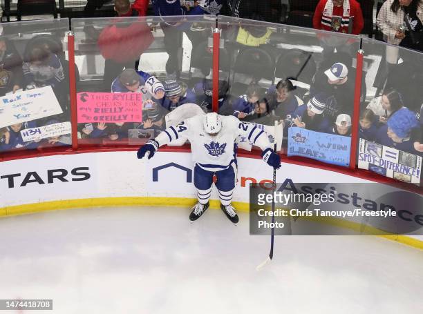 Wayne Simmonds of the Toronto Maple Leafs skates into the boards during warmups as fans behind him bang on the glass before a game against the Ottawa...