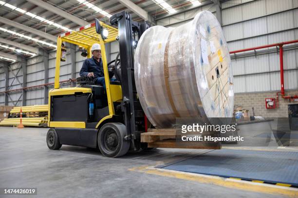 forklift operator moving a cable drum at a commercial dock - drum container stock pictures, royalty-free photos & images