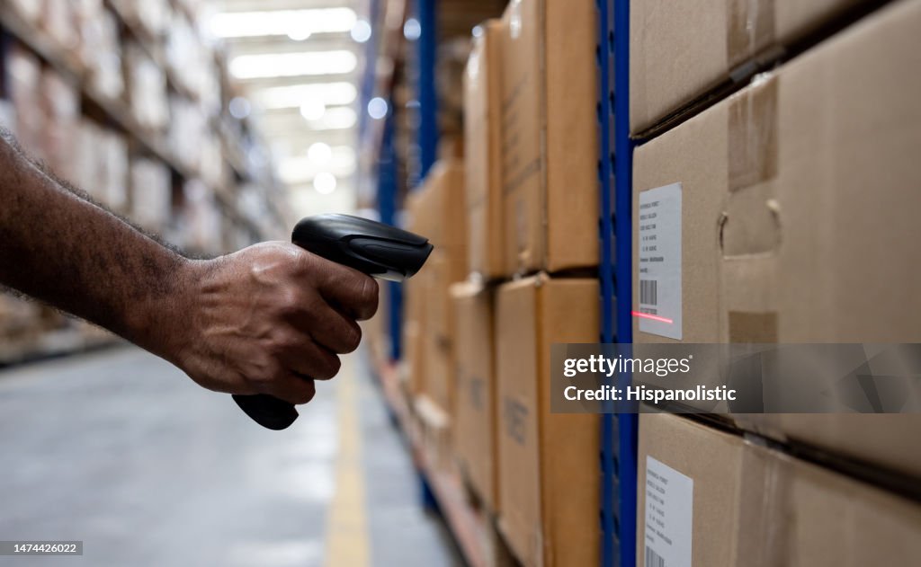 Lagerarbeiter beim Scannen eines Barcodes auf einem Karton