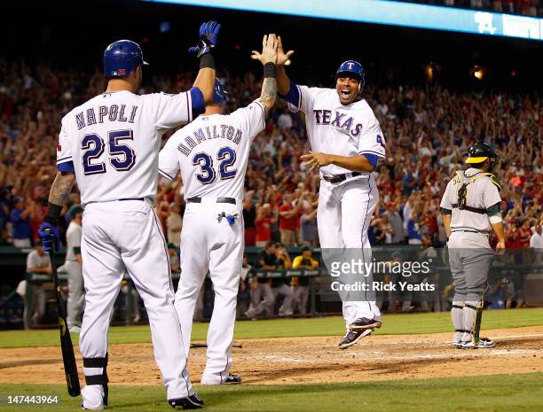 Mike Napoli of the Texas Rangers looks on as Josh Hamilton, Michael Young and Nelson Cruz score on a three-run triple by Craig Gentry in the eighth...