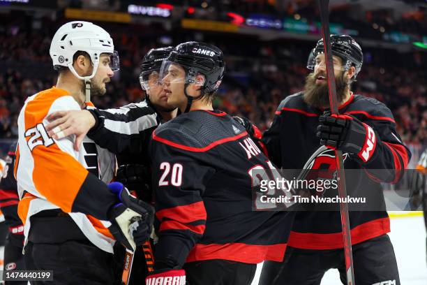 Scott Laughton of the Philadelphia Flyers and Sebastian Aho of the Carolina Hurricanes speak during the third period at Wells Fargo Center on March...
