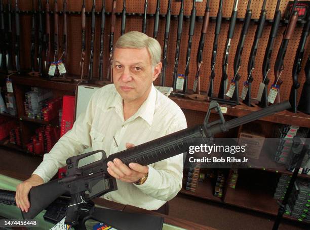 Bob K., Owner of B & B Gun Sales in North Hollywood, California holds a Bushmaster .223 rifle inside his gun shop the day after two heavily-armed...