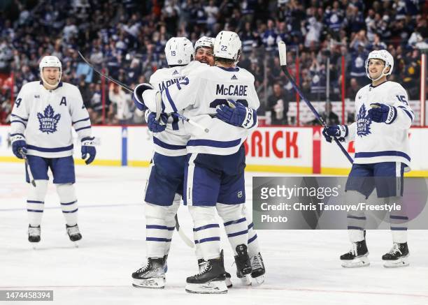 Calle Jarnkrok of the Toronto Maple Leafs celebrates his third-period goal with Auston Matthews and Jake McCabe during the game against the Ottawa...