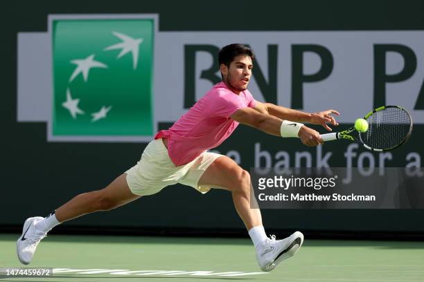 Carlos Alcaraz of Spain returns a shot to Jannik Sinner of Italy during the semifinals of the BNP Paribas Open at the Indian Wells Tennis Garden on...