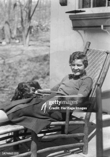 DeLamar, Alice, Miss, with dog, seated outdoors, between 1927 and 1942. Creator: Arnold Genthe.