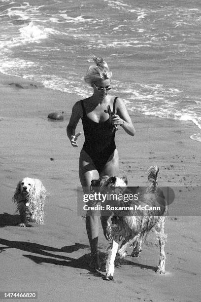 English-born American actress Nicollette Sheridan enjoys the beach with her dogs in 1996 in Malibu, California.