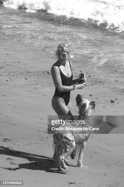 English-born American actress Nicollette Sheridan enjoys the beach with her dog in 1996 in Malibu, California.