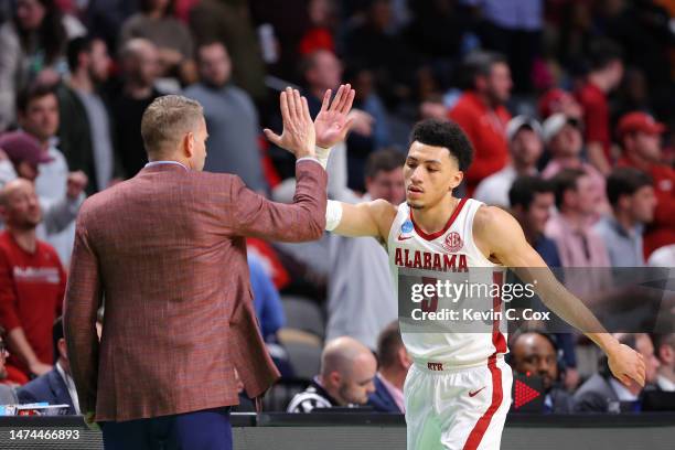 Jahvon Quinerly of the Alabama Crimson Tide gives head coach Nate Oats a high five during the second half against the Maryland Terrapins in the...