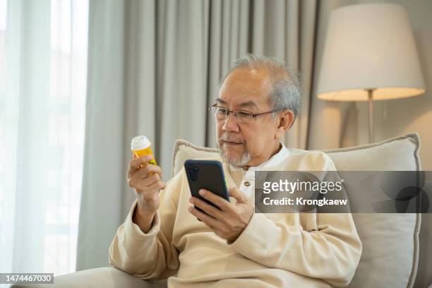elderly man checking drug label online - drug delivery ストックフォトと画像