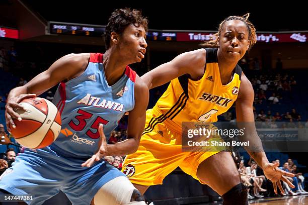 Angel McCoughtry of the Atlanta Dream moves the ball against Amber Holt of the Tulsa Shock during the WNBA game on June 29, 2012 at the BOK Center in...