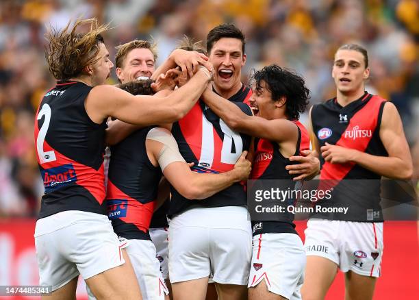 Jordan Ridley of the Bombers is congratulated by team mates after kicking a goal during the round one AFL match between Hawthorn Hawks and Essendon...