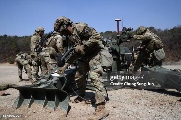 Soldiers from the 2nd Infantry Division work on an M777 howitzer during a field artillery battalion gun raid exercise as a part of joint Freedom...