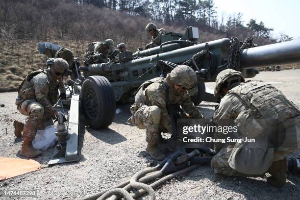 Soldiers from the 2nd Infantry Division work on an M777 howitzer during a field artillery battalion gun raid exercise as a part of joint Freedom...